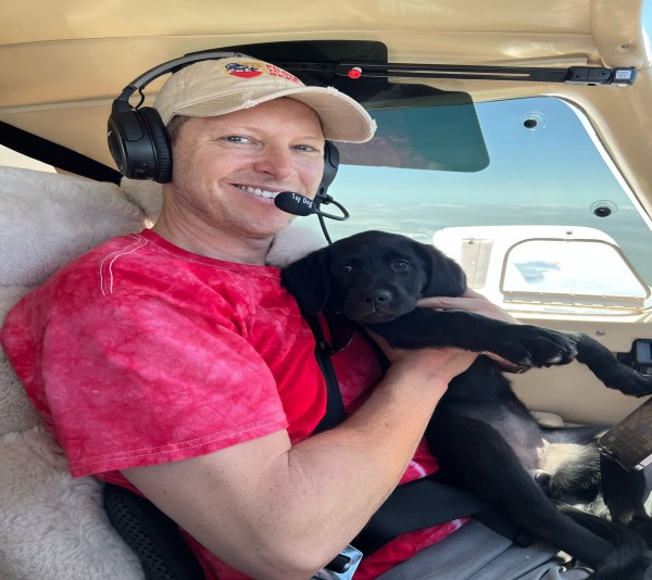 Micahel Schneider with pup on plane